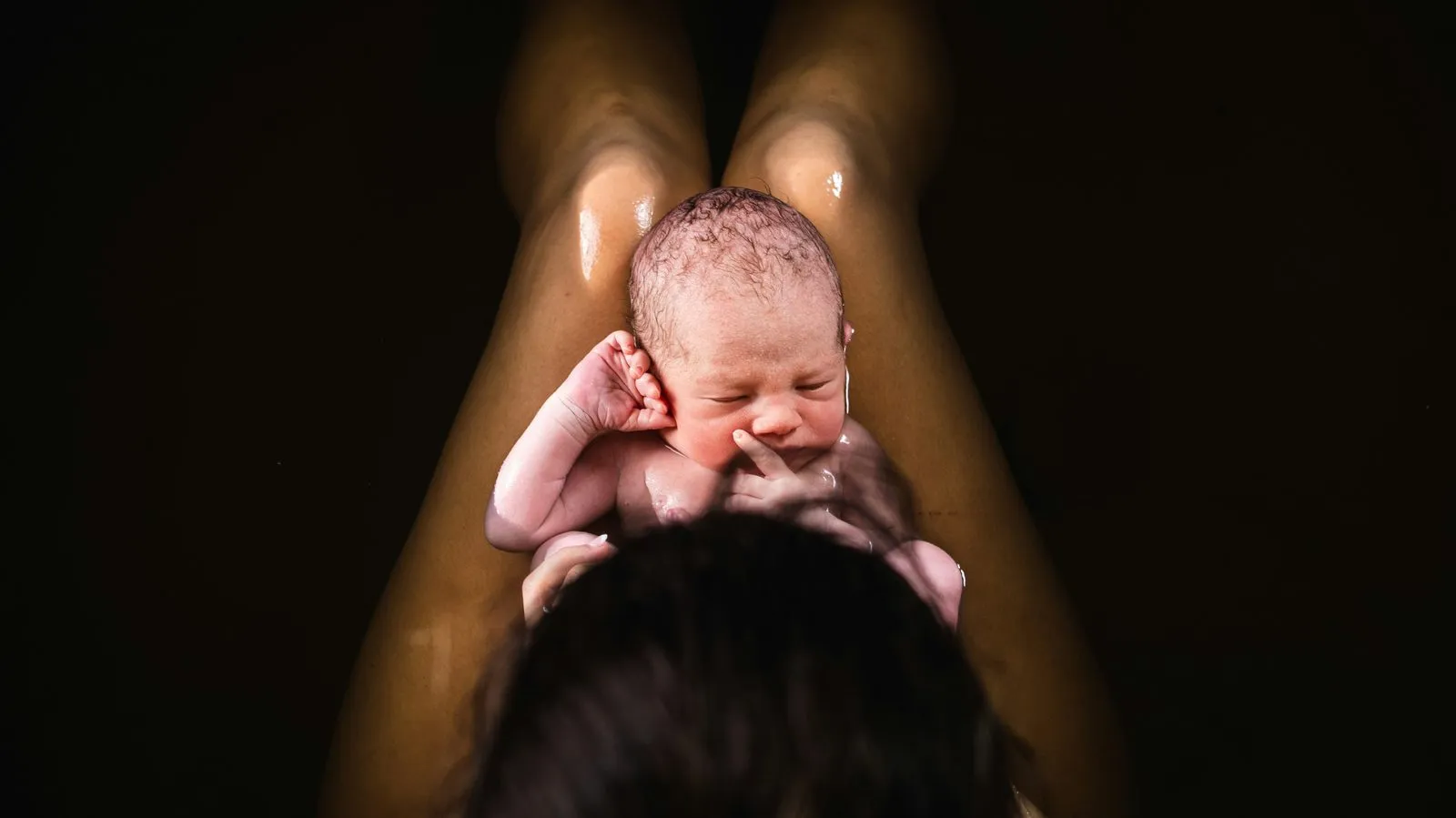 Un bébé qui vient de naître, soulevé par sa mère
