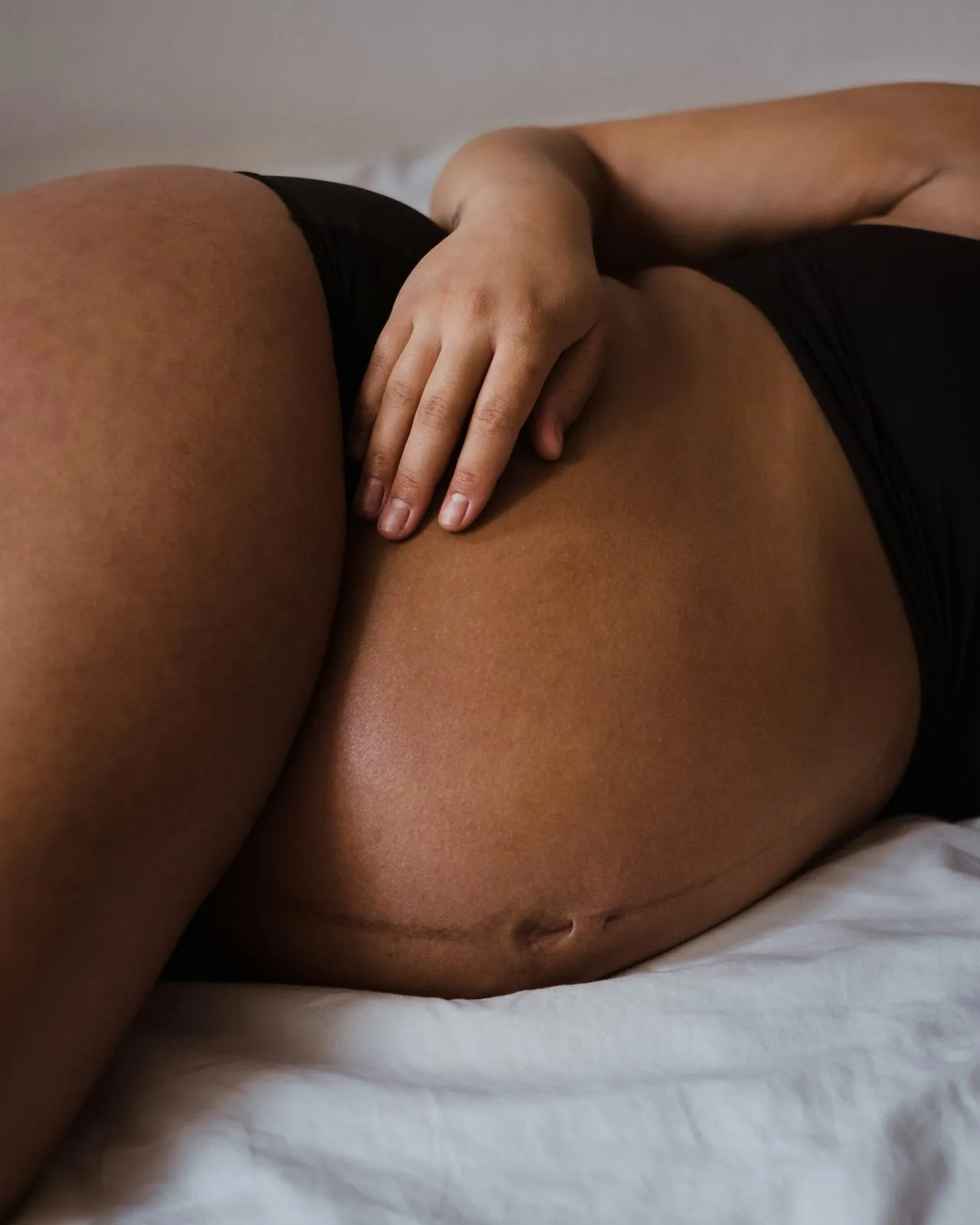 Ventre arrondi d’une femme enceinte, allongée